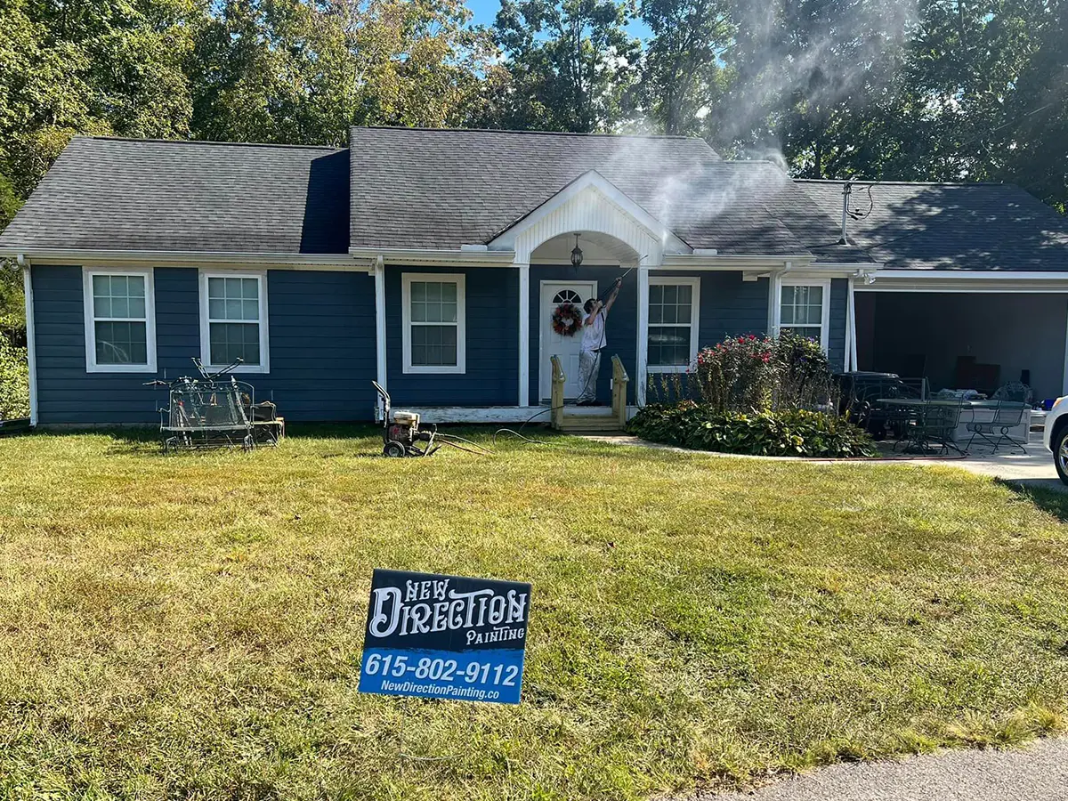 man painting house in white and blue