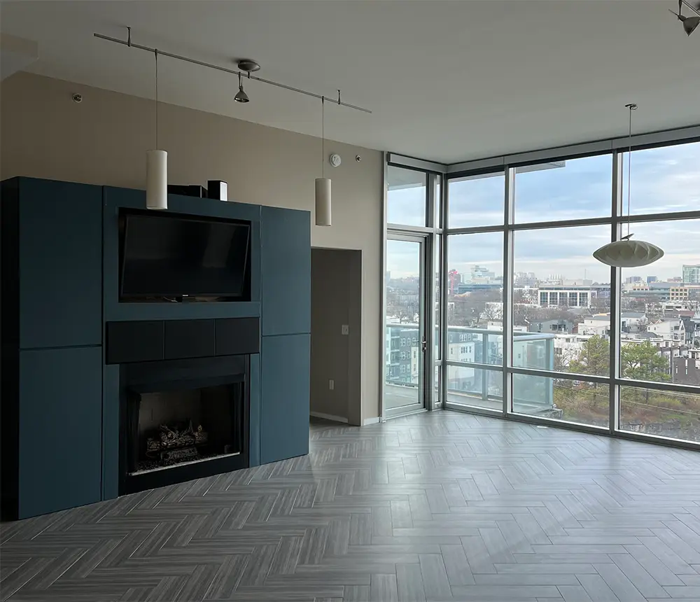 interior painting project of a room with floor-to-ceiling windows and a freshly painted fireplace and tv stand