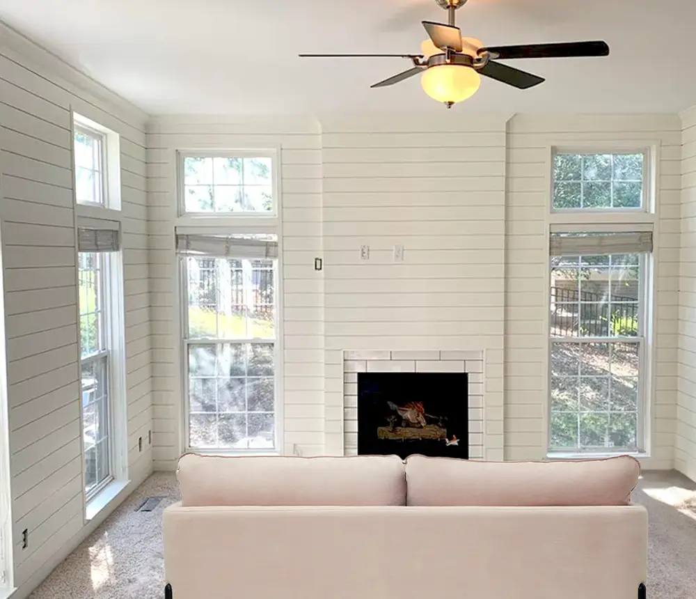 a white painted living room with a white couch and a fireplace